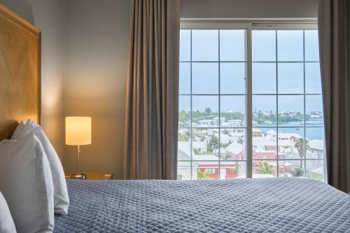 a hotel room with a bed and a large window at St George's Club in Saint George