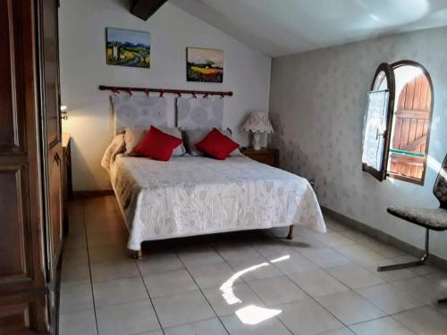 - une chambre avec un lit doté d'oreillers rouges et d'une chaise dans l'établissement Eden appartement T2 dans aile de villa, à La Londe-les-Maures