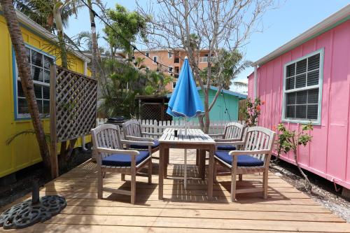 a table with chairs and a blue umbrella on a deck at Siesta Key Island Rentals in Siesta Key