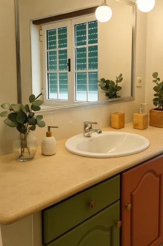 a bathroom counter with a sink and a mirror at Peach House T2 Fireplace in Ferro