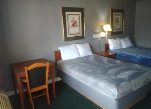 a bedroom with two beds and a table and a chair at 2 Double Beds Hotel Studio 202 in Livingston