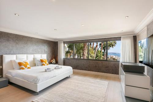 - une chambre avec un grand lit blanc et une grande fenêtre dans l'établissement Amazing villa sea view Azurenting & guest housse, à Vallauris