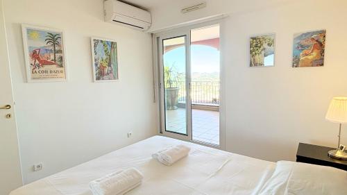 une chambre avec un lit blanc et une fenêtre dans l'établissement T3, Splendide vue Mer, Piscine, Tennis By Palmazur Vacances, à Mandelieu-la-Napoule