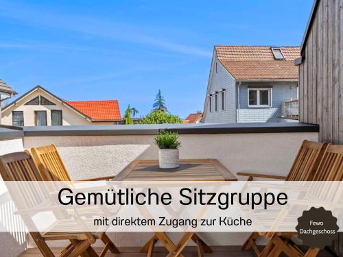 a balcony with a table and chairs and a house at Ferienhausträume-Bodensee Bergstrassen Apartments in Kreuzlingen