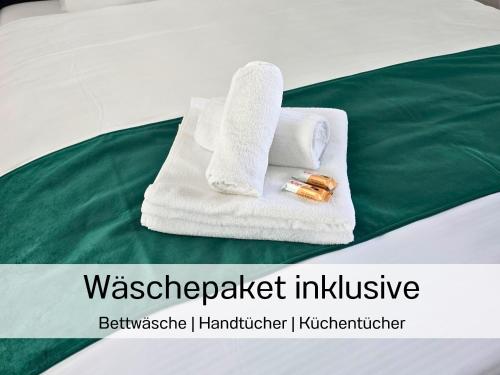 a pair of towels and a thermometer on a bed at Ferienhausträume-Bodensee Bergstrassen Apartments in Kreuzlingen