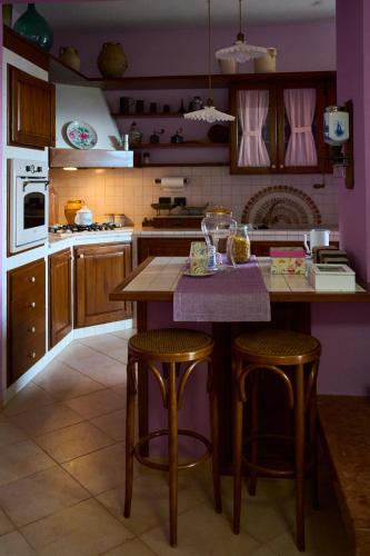Eine Küche mit lila Wänden und einer Kochinsel mit Barhockern in der Unterkunft Al Chiaro di Luna in Paternopoli