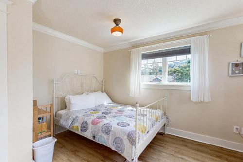 a bedroom with a white bed and a window at Clamalope in Rockaway Beach