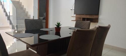 a dining room with a glass table and chairs at Lar de charme e tranquilidade em montes Claros in Montes Claros