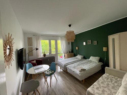 a bedroom with a bed and a table and a couch at Pokoje Ostróda Centrum in Ostróda