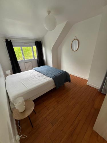 une chambre avec un grand lit et une fenêtre dans l'établissement Petite maison 2 pas du centre ville, à Lannion