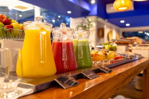 a bunch of different colored juices in jars on a counter at H4 Fortune Jardins in Sao Paulo
