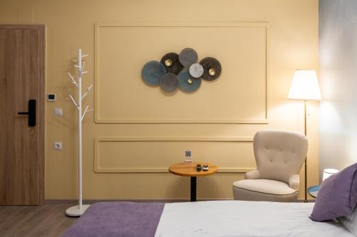 1 dormitorio con silla y reloj en la pared en HerMira House, en Sibiu