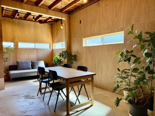a dining room with a table and chairs and a couch at Nem Kumano by WhyKumano in Nachikatsuura
