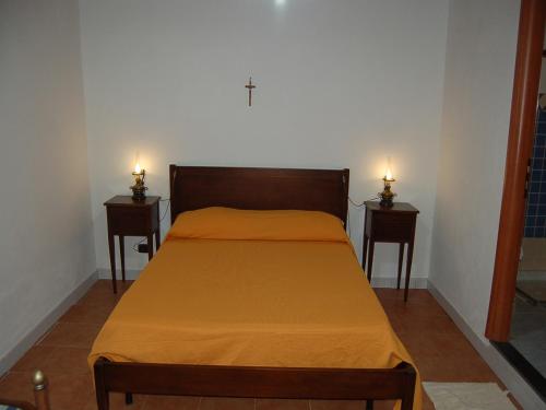 a bedroom with a bed with two lights on two tables at Hotel Al Togo Fitness & Relax in Vulcano