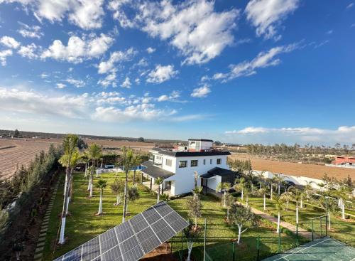 an aerial view of a white house with solar panels at Bens White House in AÃ¯n el Ksob