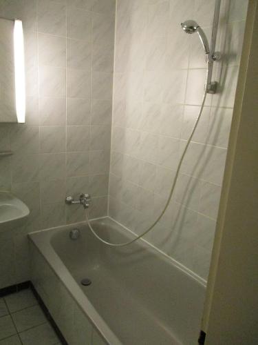 a bathroom with a tub and a shower with a hose at Kleine Wohlfühloase 2.0 in Heidelberg