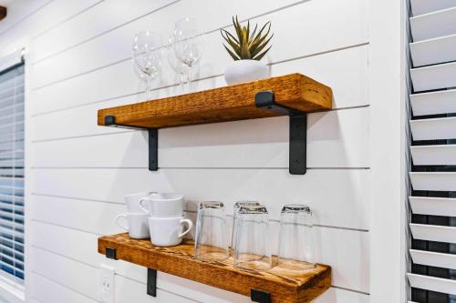 a room with wooden shelves and glasses on a wall at Stunning 2-Story Container Home with Rooftop Terrace in Bellmead