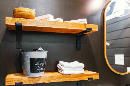 a wooden shelf with a trash can and towels on it at Stunning 2-Story Container Home with Rooftop Terrace in Bellmead