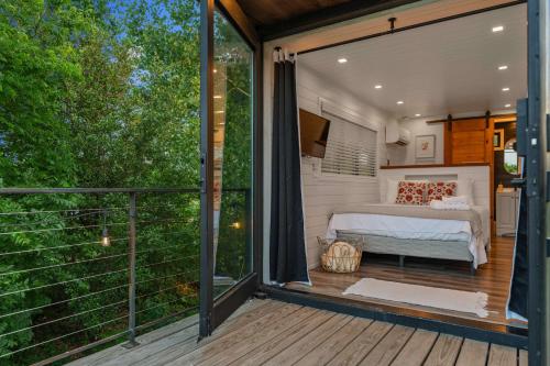 a bedroom on a deck with a bed on a balcony at Stunning 2-Story Container Home with Rooftop Terrace in Bellmead