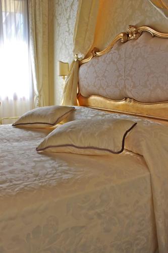 a bedroom with two beds with pillows and a window at B&B Patatina in Venice