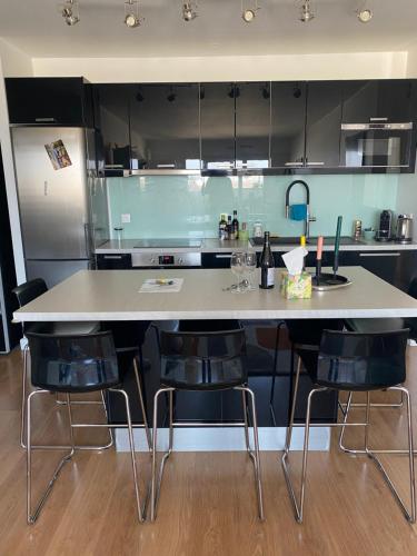 La cuisine est équipée d'une grande table, de chaises et d'un réfrigérateur. dans l'établissement A nest in Paris - 60m2 - 3 rooms, à Paris