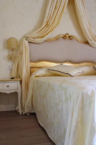a bedroom with a bed with a canopy and a side table at B&B Patatina in Venice