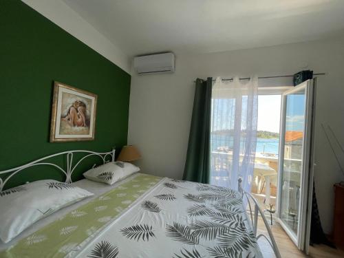 a bedroom with a bed with a green wall at Apartments Esperanza in Pašman