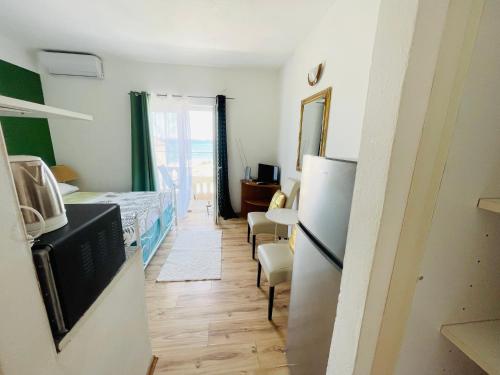 a living room with a refrigerator and a bedroom at Apartments Esperanza in Pašman