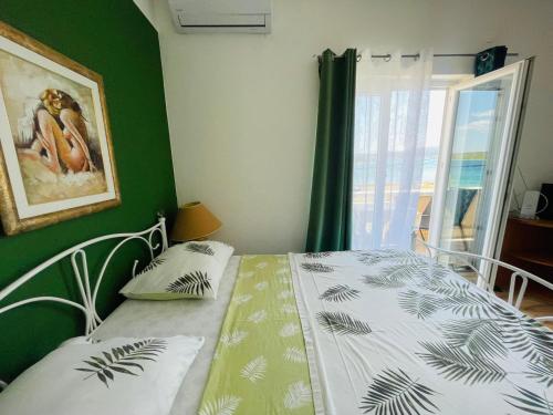 a bedroom with a bed with a green wall at Apartments Esperanza in Pašman