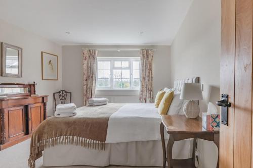 ein Schlafzimmer mit großem Bett und Fenster in der Unterkunft A Charming Cottage, Christow Dartmoor National Park in Christow