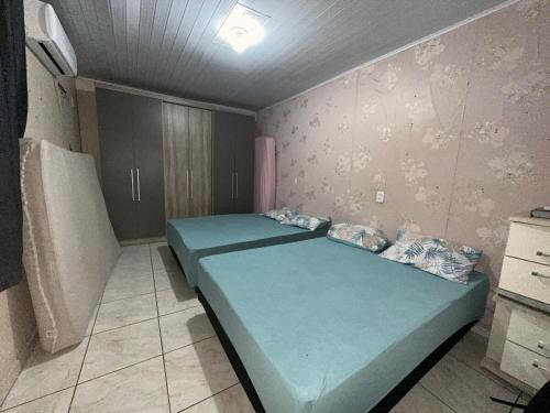 a small bedroom with a blue bed in it at Casa grande com piscina in Foz do Iguaçu