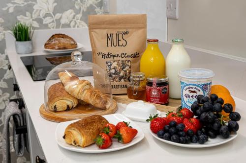 a table topped with plates of food and fruit at Scenery Hill Hideaways The Coach House Charming Retreat with Jacuzzi and BBQ Hut Near the Lake District in Workington