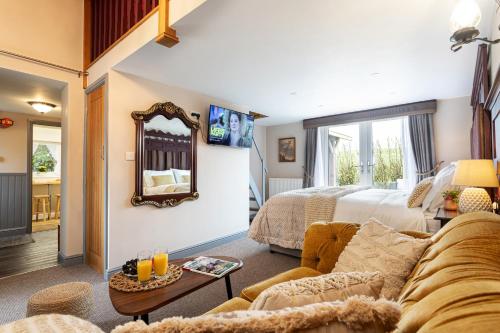 a living room with a couch and a bed at Scenery Hill Hideaways The Coach House Charming Retreat with Jacuzzi and BBQ Hut Near the Lake District in Workington