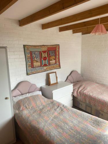 a bedroom with two beds and a picture on the wall at Waters edge in Amroth