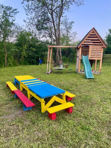 a playground with a picnic table and a play house at Moje srećno mesto in Arandjelovac