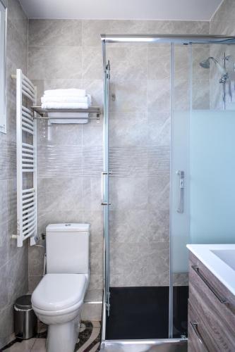 a bathroom with a toilet and a shower at La Maison Charentonneau in Maisons-Alfort