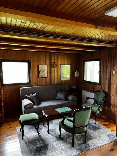 a living room with a couch and a table and chairs at Brvnara Nenadić in Užice