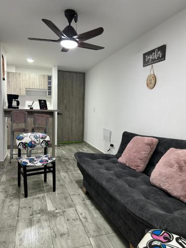 a living room with a couch and a ceiling fan at Horeb Paradise in La Tebaida