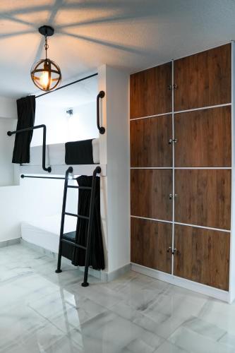 a bedroom with a bed and a wooden cabinet at Qantic Lodging & Rooftop in Medellín