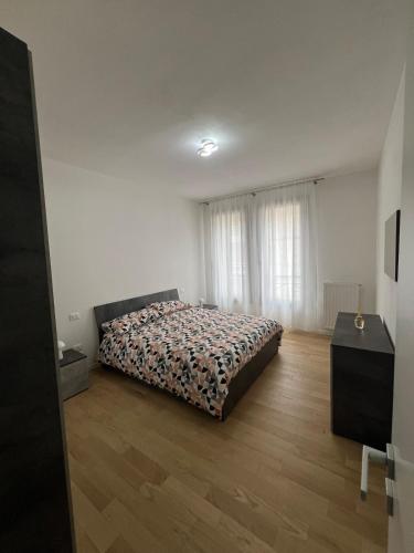 Un dormitorio con una cama y suelo de madera. en Central Charme - Conegliano, en Conegliano