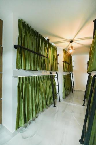a room with green curtains on the wall at Qantic Lodging & Rooftop in Medellín