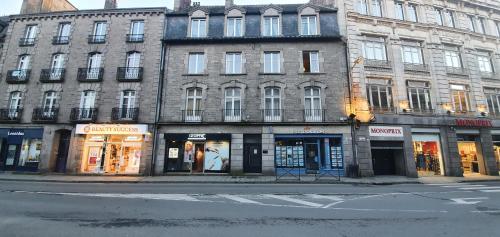 un bâtiment situé sur le côté d'une rue avec des magasins dans l'établissement Appartement T3 centre ville Parking, à Dinan