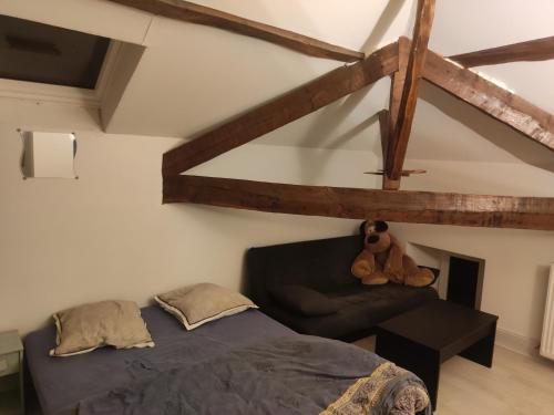 - un ours en peluche assis sur un lit dans une chambre dans l'établissement Pause à la campagne au grand air des Pyrénées, à Saint-Marcet