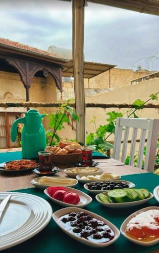 Beirut Taş Konak Otel في سانليورفا: طاولة خضراء عليها صحون طعام