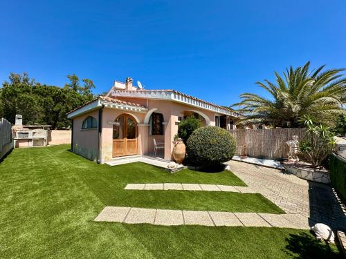 a small house with a yard with green grass at Villetta a schiera - Villasimius in Oasi dei Due Mari
