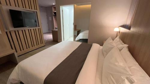 a bedroom with a large white bed with a television at VIE HOTEL in Sinop