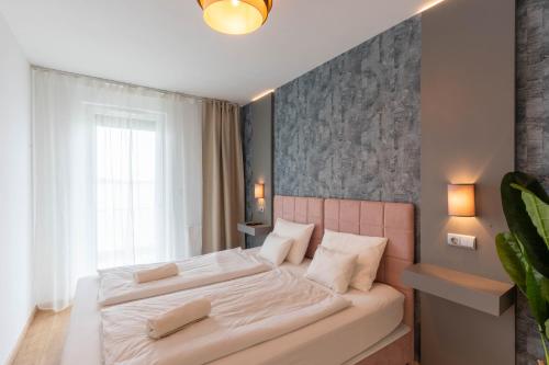 a bedroom with a large bed with white sheets at Sunset Resort 217 in Fonyód