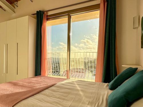 a bedroom with a bed and a large window at Chèz Cocò in La Maddalena