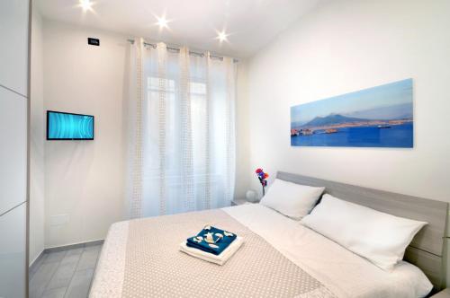 ein weißes Schlafzimmer mit einem Bett und einem TV in der Unterkunft Home Sweet Home in Neapel