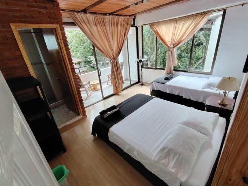 a bedroom with two beds and a balcony at Eco Hotel Entre Ríos in Villeta